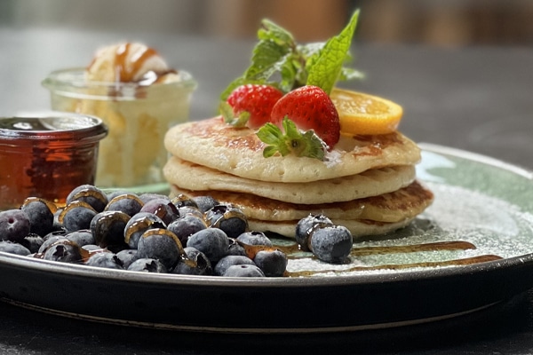 Pancakes mit Blaubeeren Frische Pancakes mit Blaubeeren und Erdbeeren im Elliot's Café